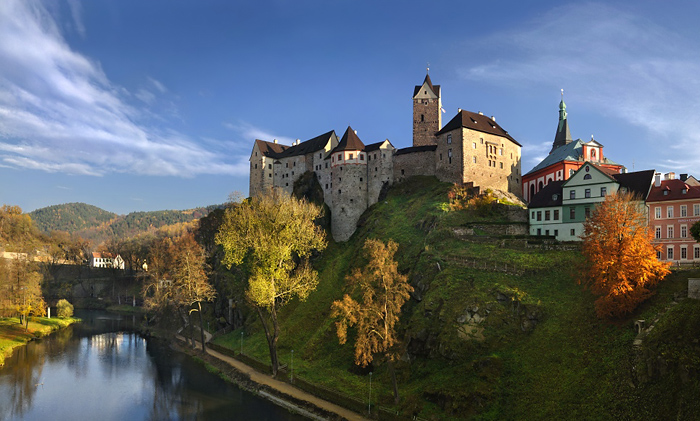 Romantický snímek zámku na ostrohu nad řekou